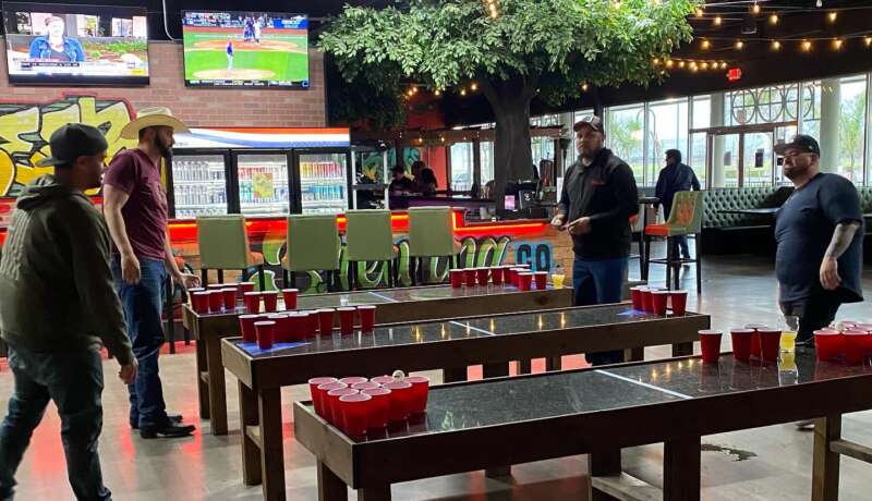 Beer pong table setup at Bay Boys Brewing with friends playing and enjoying craft beers.